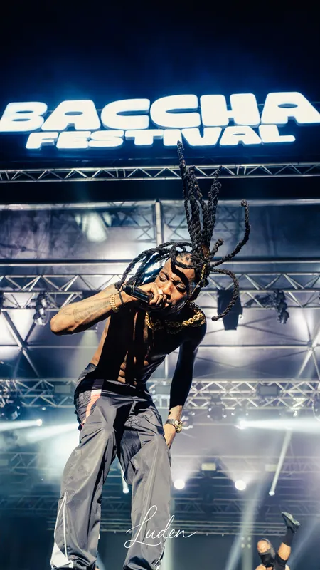 Un artiste aux longues dreadlocks, en pleine pose sur scène sous l’enseigne du Baccha Festival.